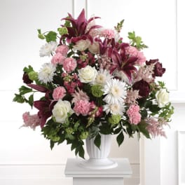 Bouquet of lilies, roses, carnations, and white daisies in a white vase