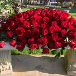 Large bouquet of red roses on a stone table outdoors