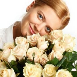 Woman holding a bouquet of cream roses