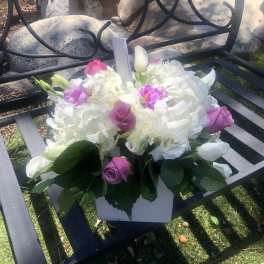 Pink and white floral arrangement in a white box