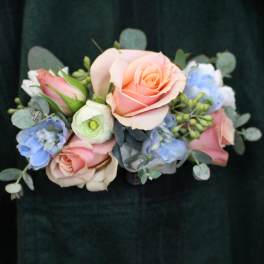 Handheld bouquet of pastel roses and blue flowers with eucalyptus