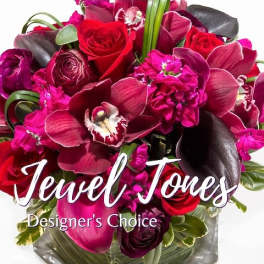Bouquet of red roses and magenta orchids with dark foliage