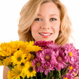 Woman holding yellow and pink daisy bouquets