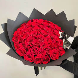 Large bouquet of red roses wrapped in black paper