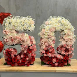 Two floral number 5 arrangements made of roses in red, pink, and white