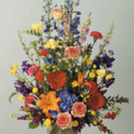 Tall mixed flower arrangement in a vase with bright multicolored blooms