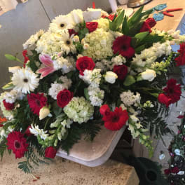 Large floral spray with red roses, white daisies, and lilies