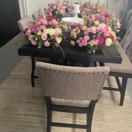 Large pink and cream floral table arrangement with a candle centerpiece