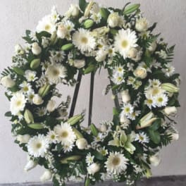 White floral wreath with daisies, roses, and lilies