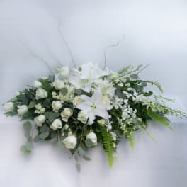 White floral casket spray with lilies and roses