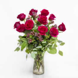 Pink roses and small pink flowers in a clear glass vase