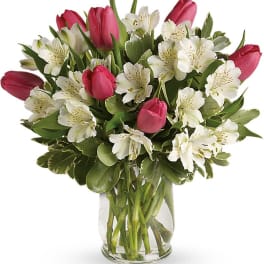 Pink tulips and white alstroemeria in a clear glass vase