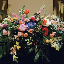 Large floral arrangement with pink, peach, white, and red blooms