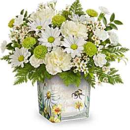 White daisies and green pom flowers in a painted glass vase