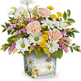 Mixed bouquet of daisies, carnations, and yellow filler flowers in a painted glass vase
