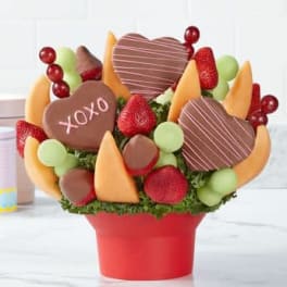 Chocolate-covered strawberries and heart-shaped treats in a red container