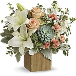 White lilies and peach roses in a wooden cube vase