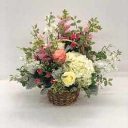 Mixed pink and white flowers in a wicker basket
