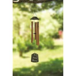 Bronze wind chime with a memorial tag hanging outdoors