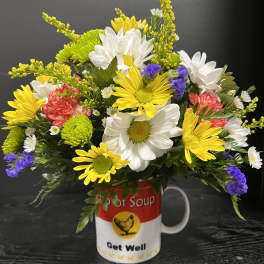 Mixed daisies and carnations arranged in a Get Well mug