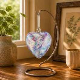 Heart-shaped iridescent glass ornament on a metal stand