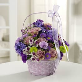 Basket of purple and pink flowers with a lavender ribbon