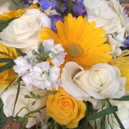 Bouquet of yellow, white, and purple flowers with a large yellow daisy