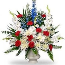 Red, white, and blue floral arrangement in a white vase