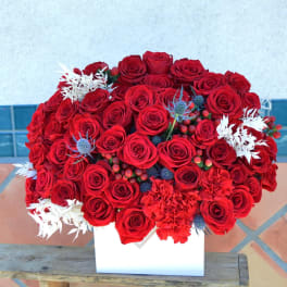 Large bouquet of red roses with white accents in a white box