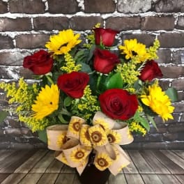 Bouquet of red roses and yellow daisies in a black vase with a sunflower ribbon