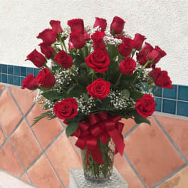 Bouquet of red roses in a glass vase with a red ribbon