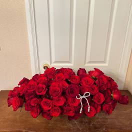 Large arrangement of red roses with a pearl bow accent