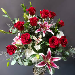 Red roses and pink lilies in a glass vase