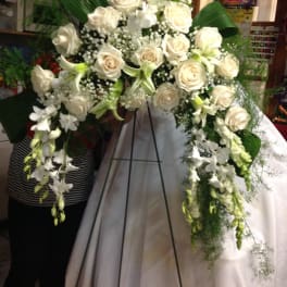 White rose funeral spray on a standing easel