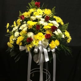 Standing floral spray with yellow and white chrysanthemums and red roses