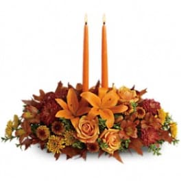 Autumn floral centerpiece with two orange taper candles