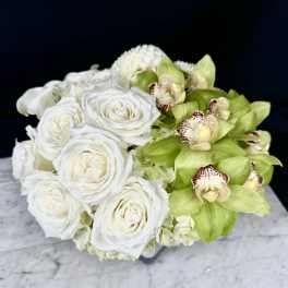 White roses and green orchids arranged in a low bouquet
