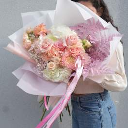 Large pastel bouquet of pink and white flowers wrapped in paper