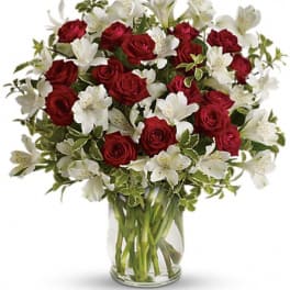 Red roses and white alstroemeria in a clear glass vase