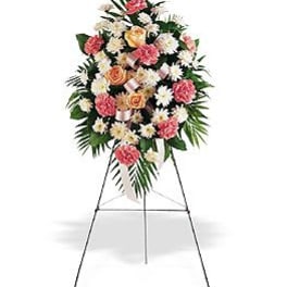 Standing funeral spray of pink and white flowers on an easel