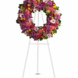 Colorful floral wreath on a white easel stand