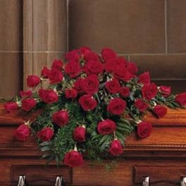 Red rose casket spray on a wooden casket