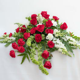 Red roses and white flowers arranged in a low spray