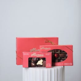 Three boxes of assorted chocolates tied with gold ribbon