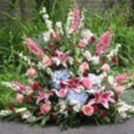 Large outdoor flower arrangement with pink lilies and mixed blooms