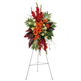 Tall standing floral spray with red and orange flowers on a metal easel