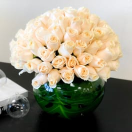 Bouquet of pale peach roses in a green glass vase