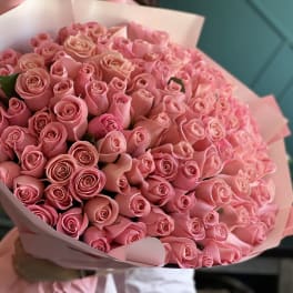 Large bouquet of pink roses wrapped in pale pink paper