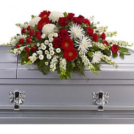 Red and white funeral spray on a gray casket