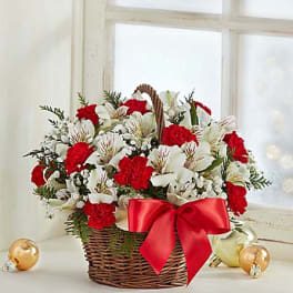 Basket of red carnations and white lilies with a red bow